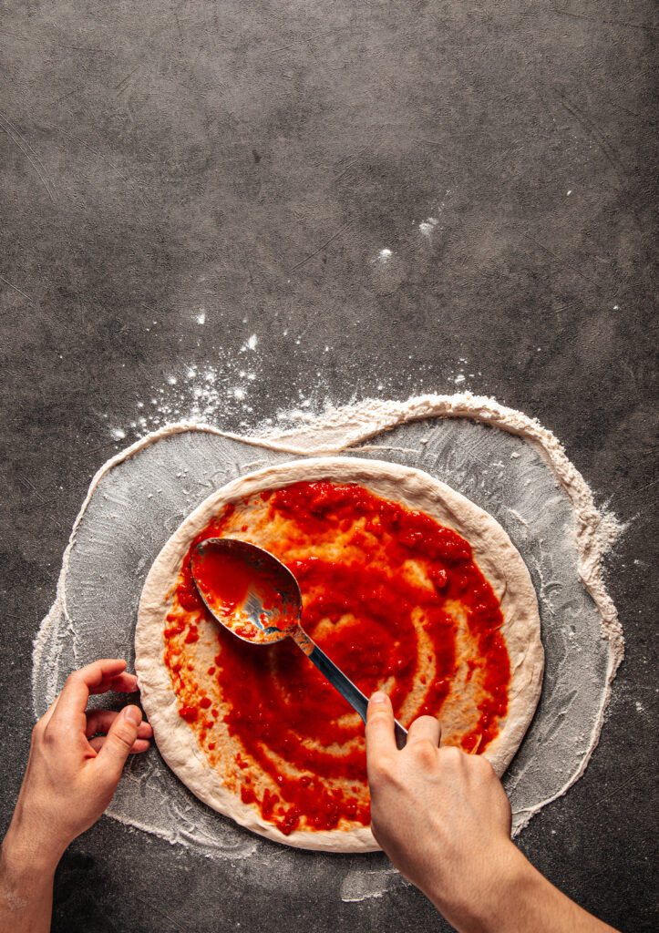 Someone making a pizza with care and love.