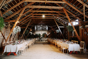Interior of an old wooden hall with decorated tables.